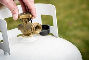 hand turning the valve on a propane tank