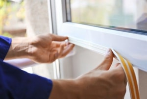 applying a strip of weather stripping to a window