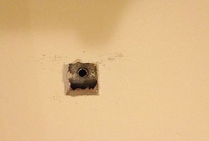 A dryer vent behind the drywall, with a hole drilled through it.