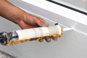 A man insulates a window.