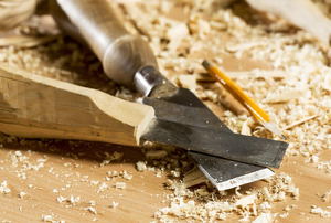 A pair of chisels surrounded by wood shavings.