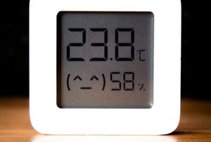 temperature and humidity sensor with light frame on wood surface