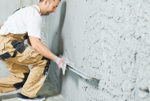 man smoothing plaster wall