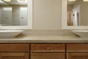 A bathroom vanity with cabinets, mirrors, and double sinks.