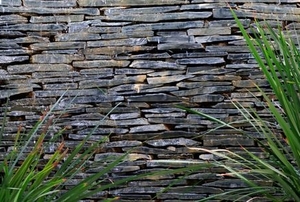 slate wall fountain with tall grasses