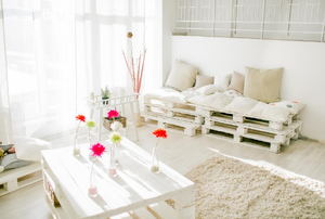 A white living room with furniture made from pallets.