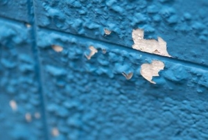 blue painted wall with bubbling damage