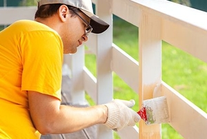 person painting wood railings