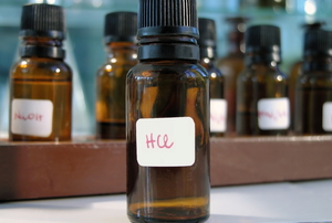 A small bottle labeled "HCL" for hydrochloric acid.