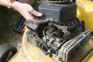 hands repairing lawn mower engine