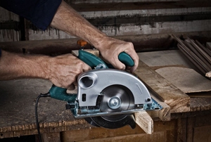 A DIYer using a circular saw to cut wood.