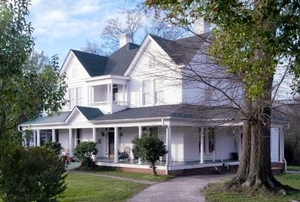 Trees placed around a Victorian home.