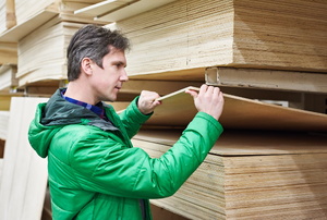 A man looks at birch plywood.