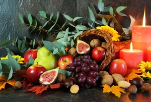 cornucopia with fruits, leaves, and red candles