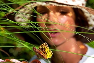 Woman watching butterfly in her garden.