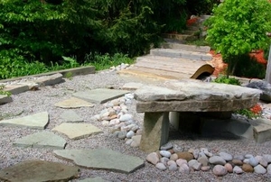 A rock-garden with flag stones and a stone table.