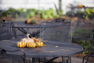A metal patio table with pumpkins on it. 