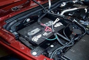 A battery connected inside of a red vehicle.
