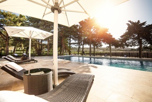 swimming pool with umbrellas and chairs nearby