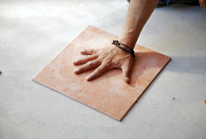 A person installs porcelain tile floor.
