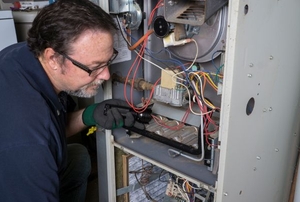 A repairman working on a furnace.