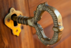 A close-up of an antique key in a door lock.