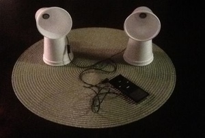 A set of speakers made from cups and earbuds.