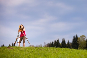 An amateur surveyor using a builder's level.
