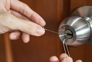 hands picking lock with paperclip