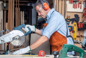 man using table saw with protective gear