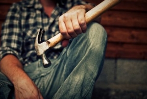 A builder holding a claw hammer.
