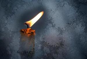 A flame burns against a dark background.