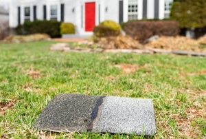 home with red door and shingle on lawn