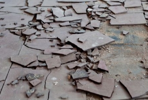 loosened, broken tiles with asbestos