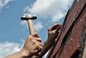 a person hammering a roof