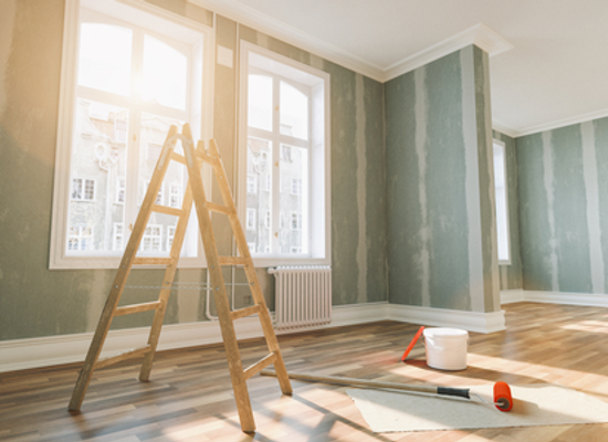 drywall installation in sunny room with ladder and window