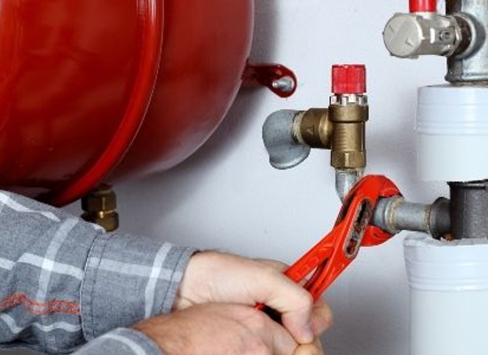 hands using wrench to fix pipes for heating system
