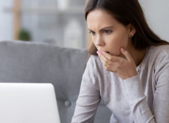 concerned woman looking at laptop