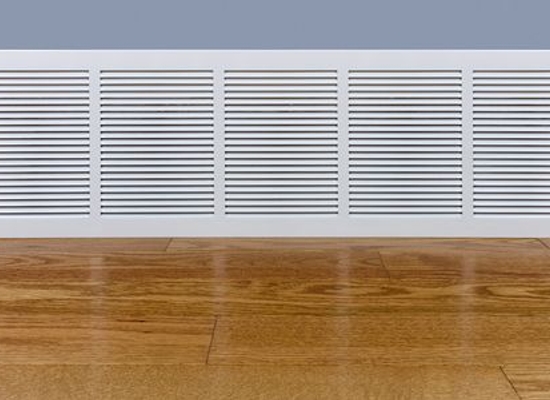 air return intake vent at base of wall by wood floor