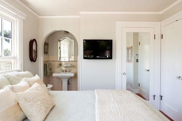 bedroom in neutral tones with wall mounted TV