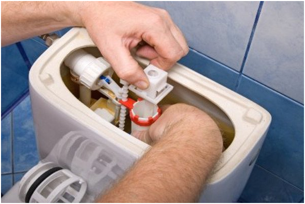 making an adjustment inside a toilet tank