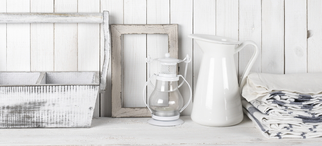 basket, frame, candle lamp, pitcher, and tea towels against a white shiplap wall