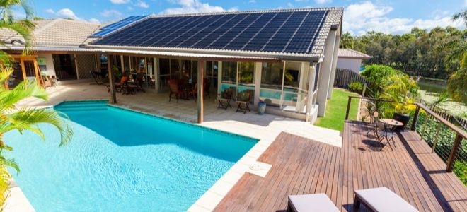 house with pool and solar panels in green neighborhood