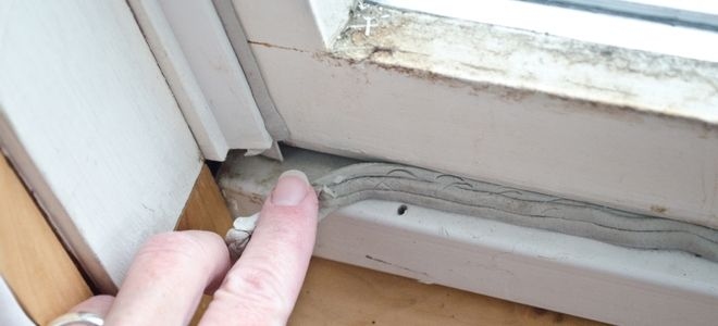 finger touching broken window seal