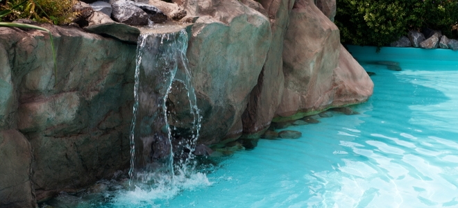 natural swimming pool design with rocks and waterfall