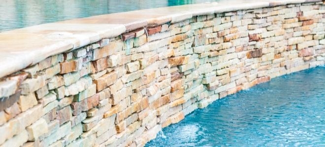 pool area with curved brick wall and trickling fountain