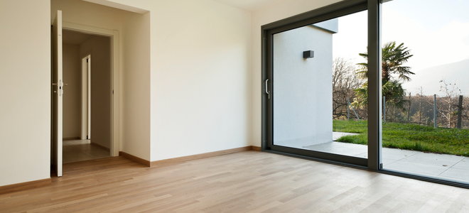laminate flooring in empty room with large sliding door