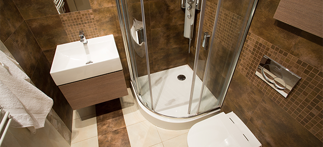 bathroom with white fixtures and glass shower doors
