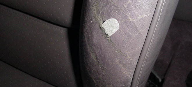 torn piece of grey leather seat in a car
