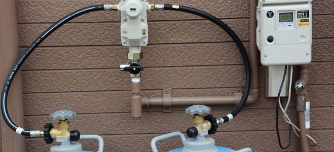 Propane tanks hooked up to the side of the house.